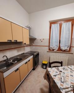 a kitchen with a sink and a table in it at B&B Il Tralcio in Cascia