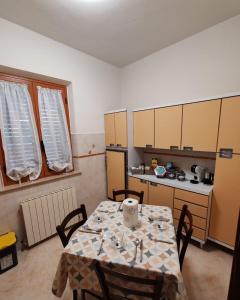 a kitchen with a table and chairs and a kitchen with a table and a counter at B&B Il Tralcio in Cascia +11 photos