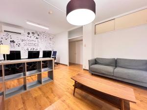 a living room with a couch and a table at 北浜703 3ベッドルーム貸切 高松港近く 最大6名 in Takamatsu
