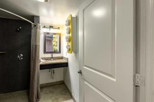 a bathroom with a sink and a mirror and a door at Hotel Elizabeth Near Newark Liberty International Airport New Jersey in Elizabeth