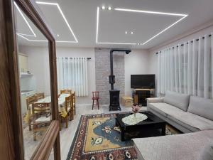 a living room with a couch and a table at Green Oasis Villa in Voskopojë