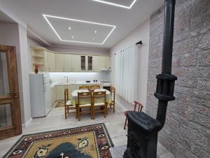 a kitchen and dining room with a black stove at Green Oasis Villa in Voskopojë