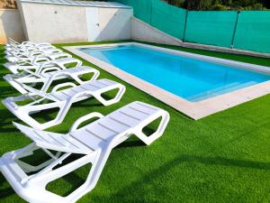 a row of lounge chairs next to a swimming pool at Casa La Huertona de Castroserna in Castroserna de Arriba