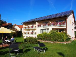 a person sitting at a table in front of a building at Gästehaus Casa Cristina in Bad Krozingen