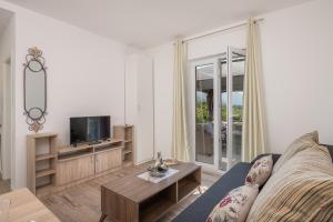 a living room with a couch and a tv at Villa Liberty 2 in Cavtat