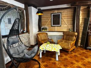 a room with two chairs and a hammock and a table at l'Orée des Moraines in Monnet-la-Ville