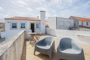 a balcony with two chairs and a table on a building at Casa "O Chafariz" in Amoreira