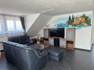 a living room with a couch and a tv at Casa Kovacs in Herbolzheim