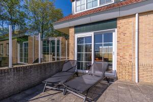 two chairs sitting on a patio in front of a house at Annabella 11 in De Koog