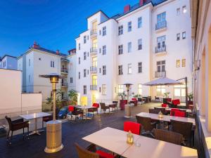 a patio with tables and chairs in front of a building at Mercure Ostrava Center in Ostrava