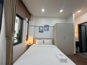 a bedroom with a large white bed and a window at SP house in Ho Chi Minh City