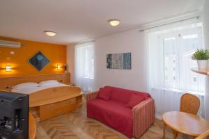 a bedroom with a red chair and a bed at Bed&Breakfast Saturn in Veli Lošinj