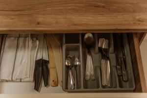 a drawer with silver utensils in a cabinet at Lyra Apartment 2 in Sfântu-Gheorghe +27 photos