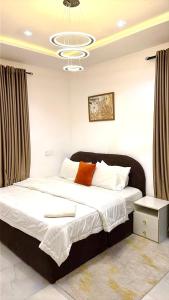 a bedroom with a large bed with a chandelier at Premium Height in Ikate