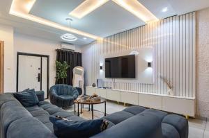 a living room with a blue couch and a tv at Premium Height in Ikate