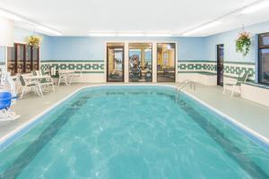 a large pool in a room with chairs and tables at Ramada Limited Decatur in Forsyth