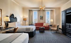 a hotel room with a bed and a couch and a chair at French Quarter Inn in Charleston +50 photos
