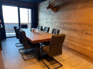 a dining room with a wooden table and chairs at Les Appartements de Maé in Val Thorens