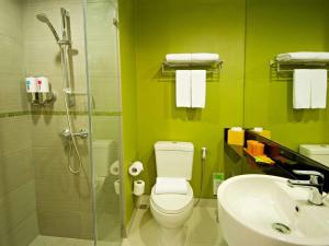 a bathroom with a shower and a toilet and a sink at ibis Styles Krabi Ao Nang in Ao Nang Beach
