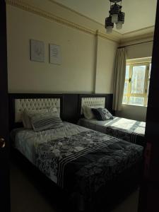 a bedroom with two beds and a window at Ras elbar Palace in Ras El Bar