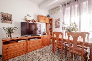 a living room with a television on a wooden entertainment center at Piso DE-MI-LA in Aspe