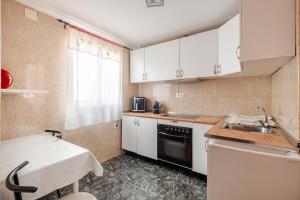 a small kitchen with white cabinets and a sink at Piso DE-MI-LA in Aspe