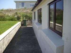 a sidewalk next to a building with a window at C19 Old Range, Riviere Towans in Hayle +5 photos