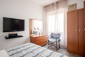 a bedroom with a bed and a tv and a chair at Piso DE-MI-LA in Aspe