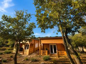 a cabin with trees in front of it at Chalet Chêne-Pin in Boutenac