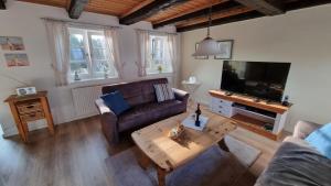 a living room with a couch and a coffee table at Rosenhaus in Kappeln +8 photos