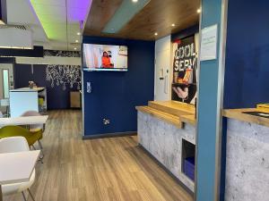 a meeting room with a blue wall and a counter at ibis budget Belfast City Centre in Belfast