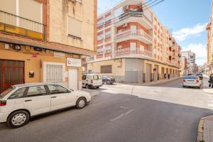 a white car parked on a city street with buildings at Piso DE-MI-LA in Aspe