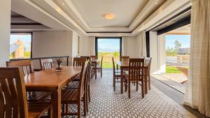 a dining room with a table and chairs and a large window at Villa TIGMIZEN - 10CH - Piscine chauffée et Spa - Marrakech in El Aouina