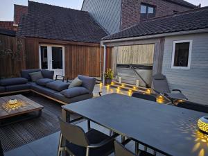 a patio with a table and chairs on a deck at Huisje Well Tevree in Roesbrugge-Haringe