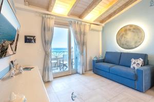 a living room with a blue couch and a view of the ocean at Blue Moon in Castelsardo