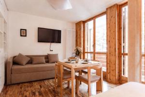 a living room with a table and a couch at Loft a Canazei vicino alle piste vista Marmolada in Alba di Canazei