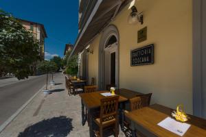 restauracja z drewnianymi stołami i krzesłami na ulicy w obiekcie Hotel Corallo w Montecatini Terme