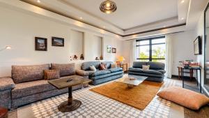 a living room with a couch and a table at Villa TIGMIZEN - 10CH - Piscine chauffée et Spa - Marrakech in El Aouina