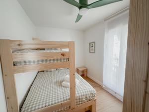 two bunk beds in a room with a ceiling fan at Apartaments Angelina in La Pobla de Segur