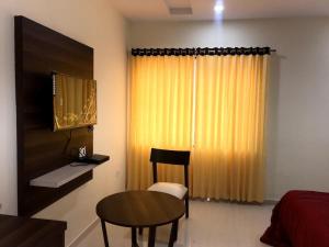 a bedroom with a table and a bed and a table and chair at Hotel Satkar in Amalāpuram +7 photos