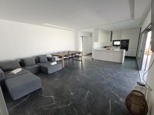 a living room with a couch and a table and a kitchen at IROC Private Garden in Quinta do Anjo