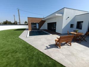 a backyard with a bench and a table and a building at IROC Private Garden in Quinta do Anjo