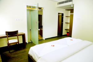 a bedroom with a bed and a chair and a mirror at Hotel Satkar in Amalāpuram