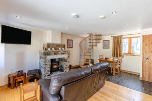 a living room with a leather couch and a fireplace at 1 Bed in Bideford oc-labdr in Woolfardisworthy