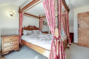 a bedroom with a four poster bed with red curtains at 1 Bed in Bideford oc-labdr in Woolfardisworthy