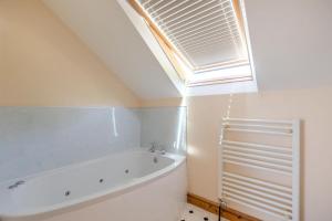a bathroom with a bath tub and a window at 1 Bed in Bideford oc-labdr in Woolfardisworthy +17 photos