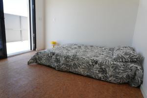 a bed in a bedroom with a blanket on the floor at IROC Private Garden in Quinta do Anjo +44 photos