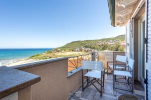 a balcony with chairs and a view of the beach at Blue Moon in Castelsardo