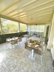 a dining area with tables and chairs in a room at B&B La Chiocciola in Castelluzzo
