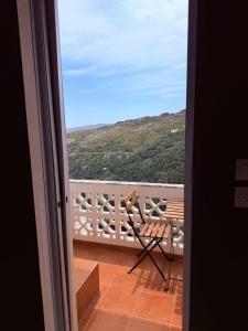 a view from a door of a balcony with a bench at Art & Motion Union - Guest Room 4 in Andros +10 photos
